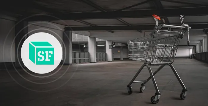 A shopping cart in a large empty room.