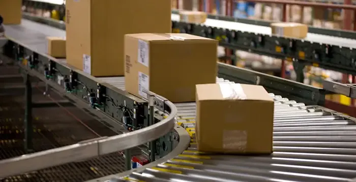 An image of packages on a conveyer belt in a warehouse.