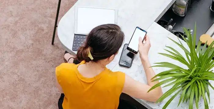 A person using a tablet and a mobile phone.