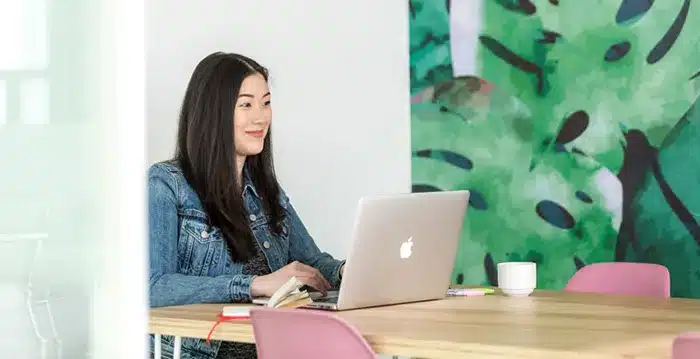 A woman sitting at a table with a laptop.